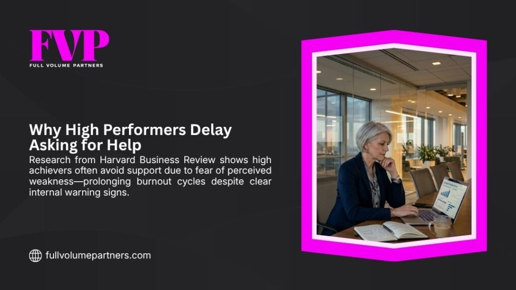 Senior female executive working alone at a laptop in an empty boardroom, reflecting why high performers delay asking for help despite clear burnout warning signs